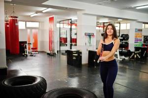 jovem mulher bonita fazendo exercícios e trabalhando duro na academia e curtindo seu processo de treinamento. foto