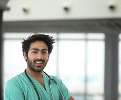 trabalhador de saúde indiano masculino vestindo um avental verde.