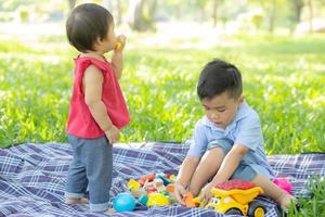 menino e menina está jogando por ideia e inspiração com bloco de brinquedo, criança aprendendo com bloco de construção para educação, atividade infantil e jogo no parque com feliz no verão. foto