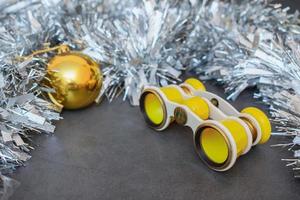 binóculos vintage de teatro amarelo surrado e decorações de natal prateadas foto