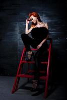 menina ruiva modelo de moda com maquiagem originalmente como predador leopardo contra parede de aço. retrato de estúdio na escada. foto