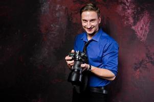 retrato de estúdio de homem elegante fotógrafo profissional com câmera, usar camisa azul e gravata. foto