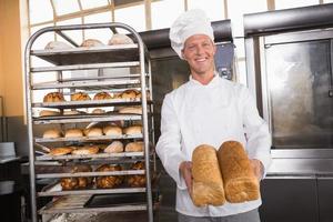 padeiro sorridente mostrando pães