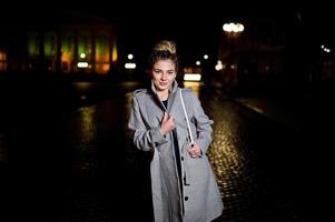 menina com dreadlocks andando na rua à noite da cidade. foto