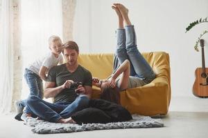 qual imagem você prefere. jovem casal com criança olhando juntos para as fotos feitas pela câmera