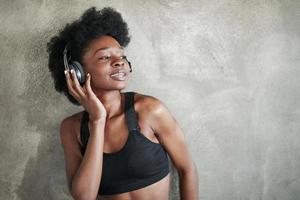olhar sonhador. retrato de garota afro-americana em roupas de fitness, tendo uma pausa após o treino foto