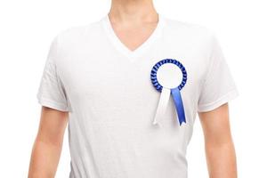 homem com camisa branca, vestindo um distintivo de prêmio azul foto