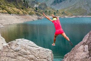 menina atleta salta entre suas pedras nas montanhas foto