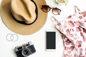 conjunto de roupas femininas de verão com acessórios em fundo branco com telefone inteligente de tela vazia, configuração plana, vista superior foto