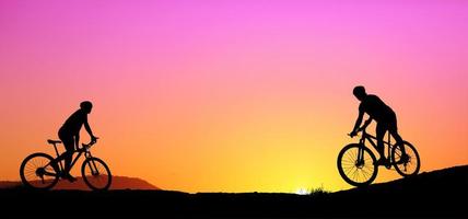 silhueta de um ciclista de montanha desfrutando de downhill durante o pôr do sol. conceito de bicicleta de montanha. corrida de mountain bike - ciclista de silhueta no fundo. foto