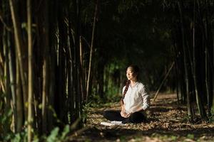 retrato linda mulher meditando na floresta de bambu foto