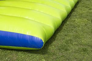 trampolim verde. escorregador inflável. pista de obstáculos. entretenimento no parque. foto