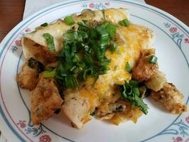 enchilada de frango com queijo e coentro no prato comida mexicana foto