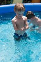 menino sorridente na piscina foto