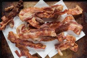 tiras de bacon fritas crocantes em papel toalha postura plana foto