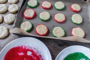 fazendo biscoitos de açúcar de natal com vista superior de granulado vermelho e verde foto