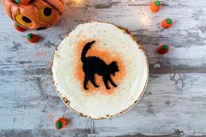 bolo de especiarias de abóbora de gato preto de halloween com decorações flat lay foto