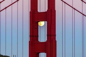 majestosa ponte golden gate de san francisco com lua cheia de junho de 2022 nascendo e a torre norte vista de marin promontórios na califórnia foto