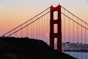 majestosa ponte golden gate de san francisco com lua cheia de junho de 2022 nascendo e a torre norte vista de marin promontórios na califórnia foto