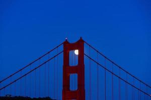 majestosa ponte golden gate de san francisco com lua cheia de junho de 2022 subindo mostrando a torre norte dos promontórios de marin foto