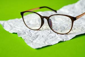 papel amassado branco e papel verde. conceito de óculos. foto