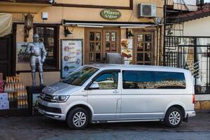 side turkey 20 de fevereiro de 2022 silver volkswagen transportador está estacionado na rua em um dia quente de verão contra o pano de fundo de uma loja foto