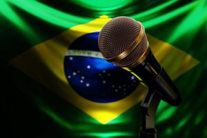 microfone no fundo da bandeira nacional do brasil, ilustração 3d realista. prêmio de música, karaokê, rádio e equipamentos de som de estúdio de gravação foto
