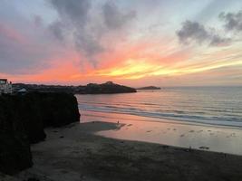 uma vista de um pôr do sol sobre newquay em cornwall foto