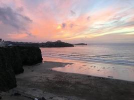 uma vista de um pôr do sol sobre newquay em cornwall foto