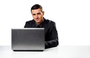 empresário sentado à mesa com o laptop foto