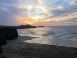 uma vista de um pôr do sol sobre newquay em cornwall foto