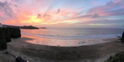 uma vista de um pôr do sol sobre newquay em cornwall foto