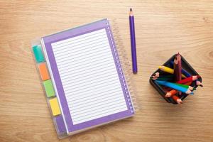 mesa de escritório com o bloco de notas em branco e lápis coloridos