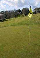 campo de golfe com vara de bandeira em um dia ensolarado foto