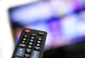 controle remoto e tela - assistir ao programa de TV favorito foto