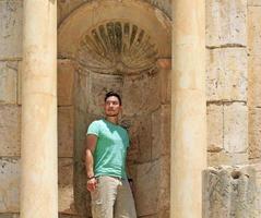 jovem posando como uma estátua nas ruínas romanas de jerash, jordânia foto