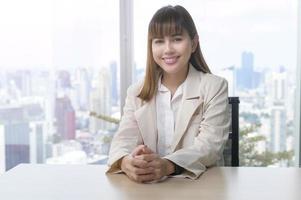 retrato de uma jovem mulher de negócios linda sorrindo no escritório moderno foto