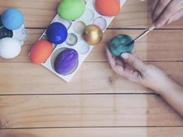 pessoas pintando ovos de páscoa coloridos - conceito de celebração do feriado de páscoa foto