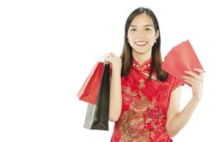 feliz senhora asiática fazendo compras na suíte chinesa isolada sobre o espaço branco da cópia - conceito do dia da mulher foto