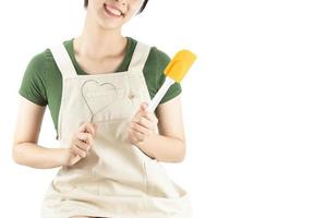 senhora feliz segurando coisas de cozinha sobre fundo de espaço de cópia - conceito de preparação de comida caseira de pessoas foto