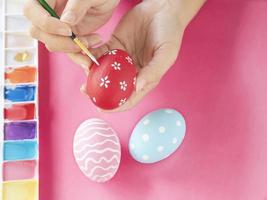 pessoas pintando ovos de páscoa coloridos - conceito de celebração do feriado de páscoa foto