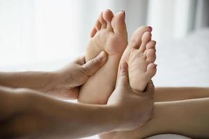 mulher recebendo serviço de massagem nos pés do massagista close-up na mão e no pé - relaxe no conceito de serviço de massagem terapêutica nos pés foto
