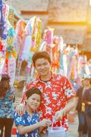 família tailandesa participa de antiga atividade tradicional em um templo durante o festival songkran em chiang mai, norte da tailândia, evento muito famoso da tailândia foto