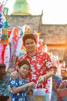 família tailandesa participa de antiga atividade tradicional em um templo durante o festival songkran em chiang mai, norte da tailândia, evento muito famoso da tailândia foto