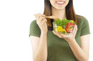senhora feliz gosta de comer salada de legumes sobre fundo de espaço de cópia branco - pessoas com conceito de alimentos orgânicos saudáveis foto