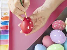 pessoas pintando ovos de páscoa coloridos - conceito de celebração do feriado de páscoa foto