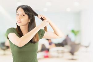 mulher de beleza cuida do cabelo dela usando maca de cabelo isolada sobre fundo branco - pessoas com conceito de cuidados com o cabelo foto