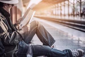 homem de viagem espera trem na plataforma - atividades de estilo de vida de férias de pessoas no conceito de transporte de estação de trem foto