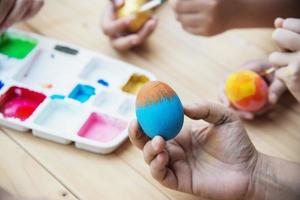 pessoas pintando ovos de páscoa coloridos - conceito de celebração do feriado de páscoa foto