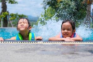 duas meninas bonitinhas brincando na piscina. conceito de estilo de vida de verão.